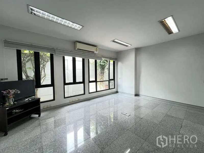 Office Space for sale in Bang Na, Bangkok - Ground-floor office room with floor‑to‑ceiling windows and AC unit.