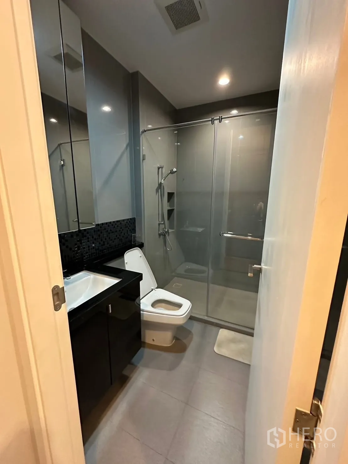 คอนโด for rent or sale in Chatuchak, Bangkok - ห้องน้ำโมเดิร์นพร้อมตู้ชาวเวอร์กระจก เคาน์เตอร์อ่าง และโถสุขภัณฑ์