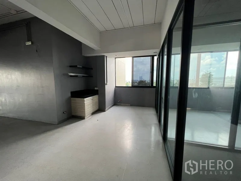 Office Space for rent in Mueang Samut Prakan, Samut Prakan - Office nook with shelves and a window beside a glass-enclosed balcony.