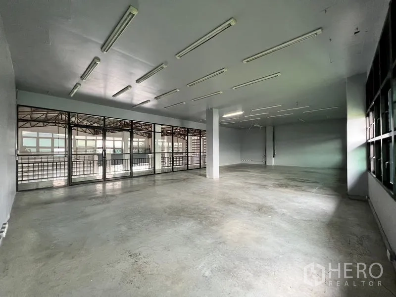 Warehouse for rent in Min Buri, Bangkok - Upstairs office space with sliding glass doors opening to a balcony walkway.