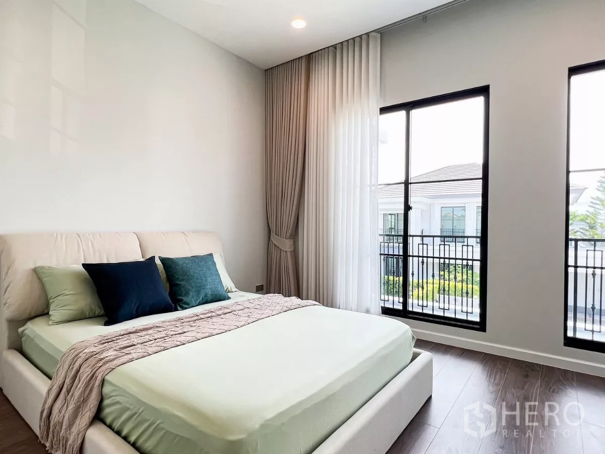 บ้าน ให้เช่าในKhan Na Yao, Bangkok - ห้องนอนผ้าปูสีเขียวอ่อน หน้าต่างสูงจรดพื้น มองเห็นระเบียงเหล็กดัด