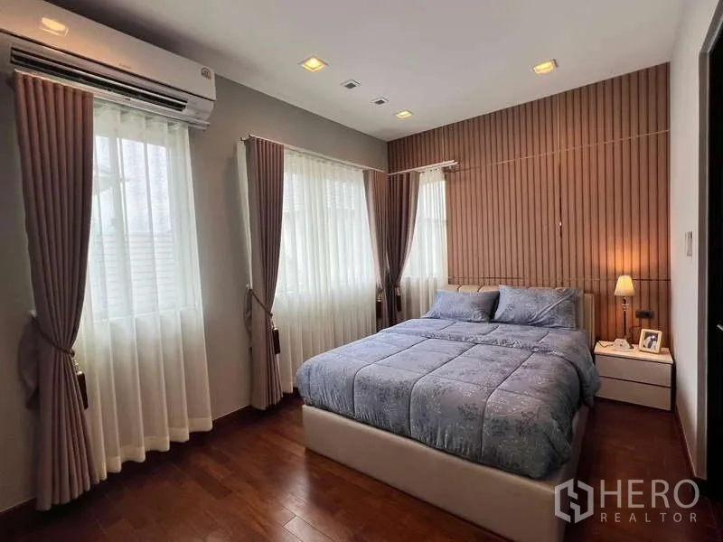 บ้าน ให้เช่าหรือขายในLat Krabang, Bangkok - ห้องนอนชุดผ้าปูสีน้ำเงิน หน้าต่างมุม และผนังลวดลายไม้เซาะร่อง