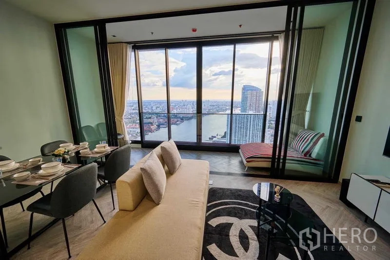 คอนโด ให้เช่าในKhlong San, Bangkok - โซนนั่งเล่นและรับประทานอาหารพร้อมฉากกั้นกระจกและระเบียงชมวิวเมืองและแม่น้ำ