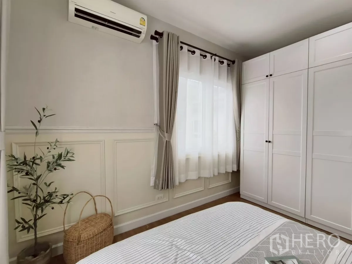 独立式住宅 出租在Khlong Luang, Pathum Thani - 卧室一角，白色衣柜、窗帘与盆栽