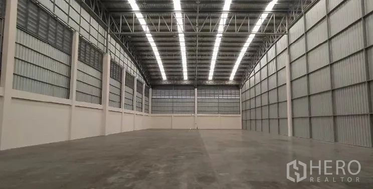 คลังสินค้า ให้เช่าในSamut Prakan - พื้นโกดังไร้เสากีดขวางภายใต้หลังคาเหล็กทรงจั่วสูงพร้อมไฟแถวยาว