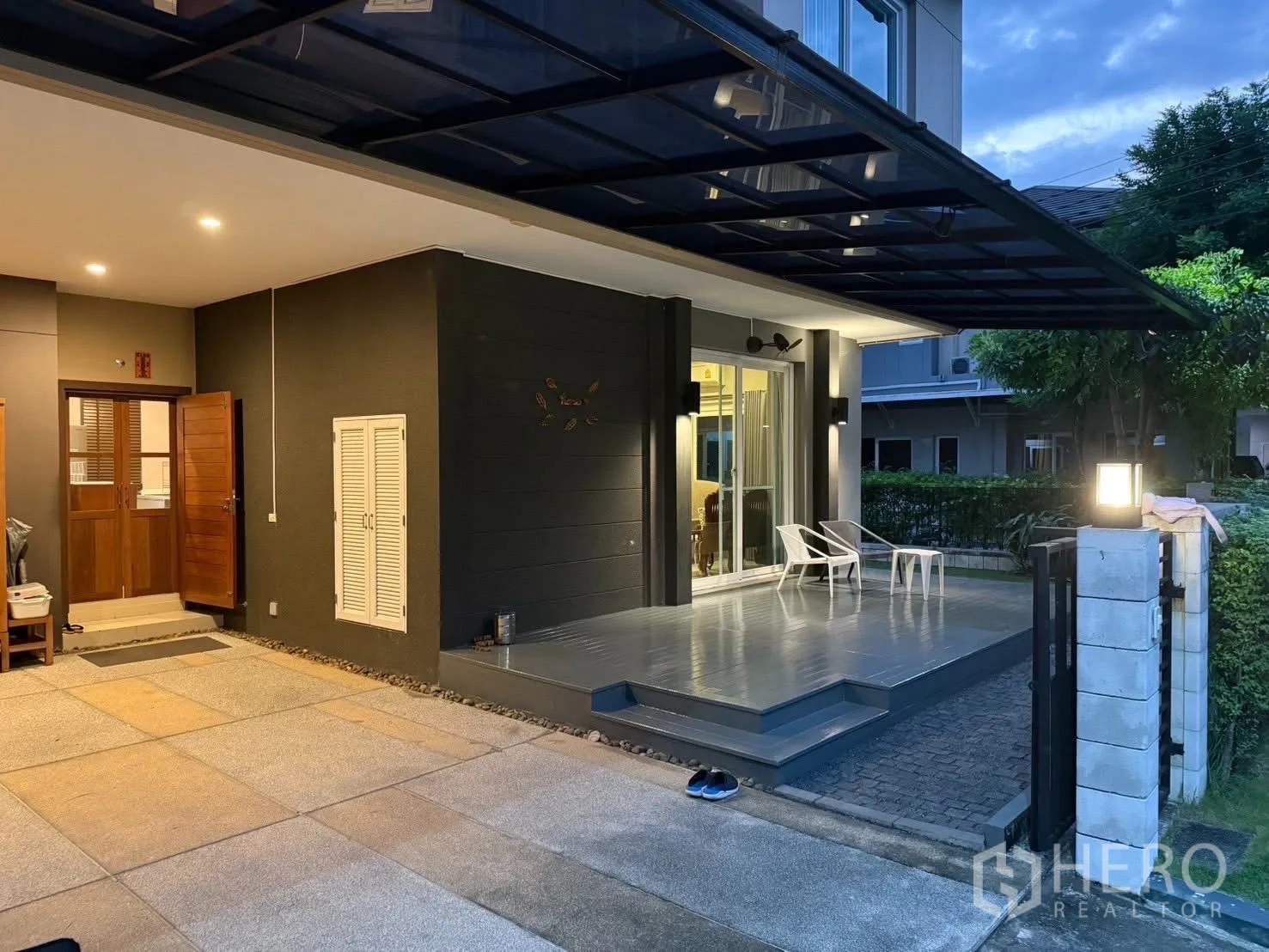 Detached House for rent in Bang Na, Bangkok - Wide view of the carport and raised terrace under a polycarbonate roof.