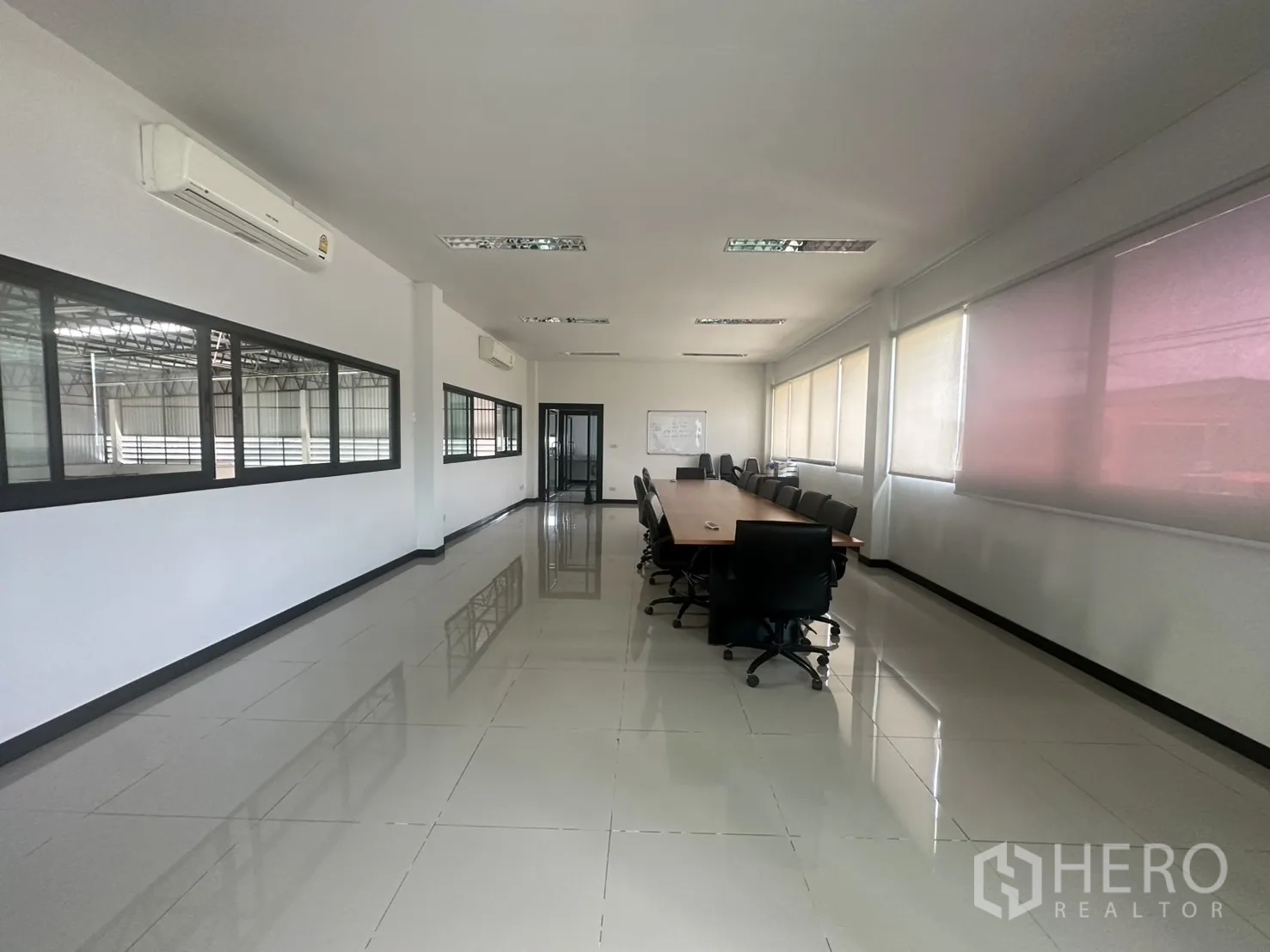 Warehouse for sale in Bang Len, Nakhon Pathom - Bright meeting room with a long conference table, tiled floors and windows.