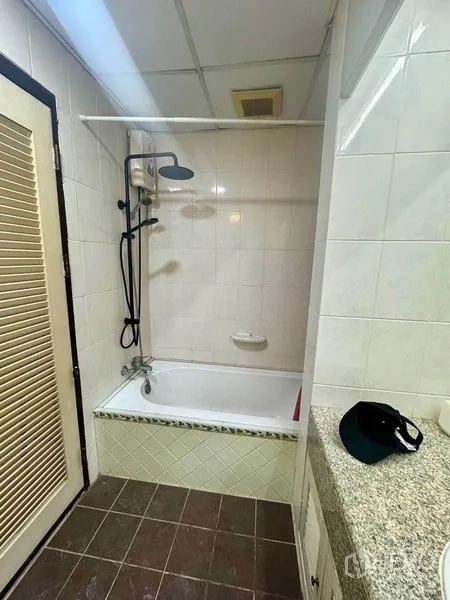 公寓 出租或出售 - 瓷砖浴室，设浴缸与顶喷花洒，旁有花岗岩台面盥洗区。