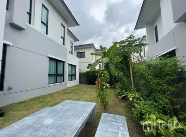 独立式住宅 出租 - 私家庭院草坪，热带绿植环绕，设有户外长凳。