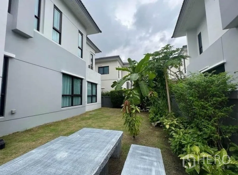 独立式住宅 出租 - 私家庭院草坪，热带绿植环绕，设有户外长凳。