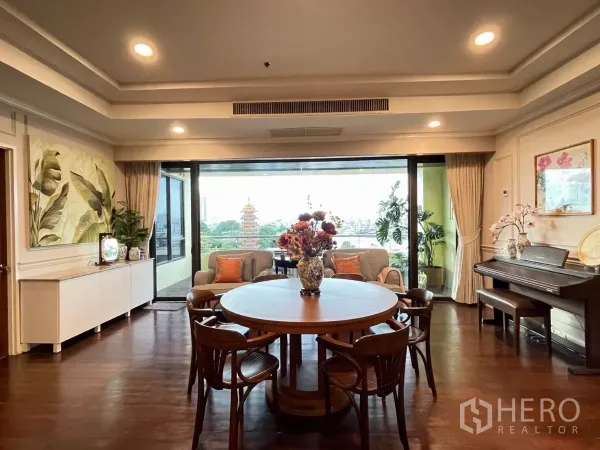 公寓 出租在Khlong San, Bangkok - 优雅的客餐厅，圆桌、钢琴，推拉落地窗通向观景阳台。