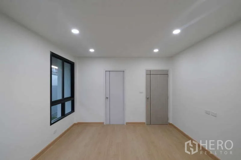 独立式住宅 出售在Bueng Kum, Bangkok - 卧室配双窗与内置柜门，简洁中性色调