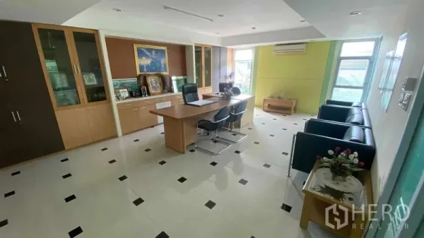 Office Space for sale in Bang Kapi, Bangkok - Executive office with desk, visitor chairs, built-in cabinets and tiled flooring.