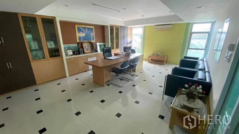 Office Space for sale in Bang Kapi, Bangkok - Executive office with desk, visitor chairs, built-in cabinets and tiled flooring.