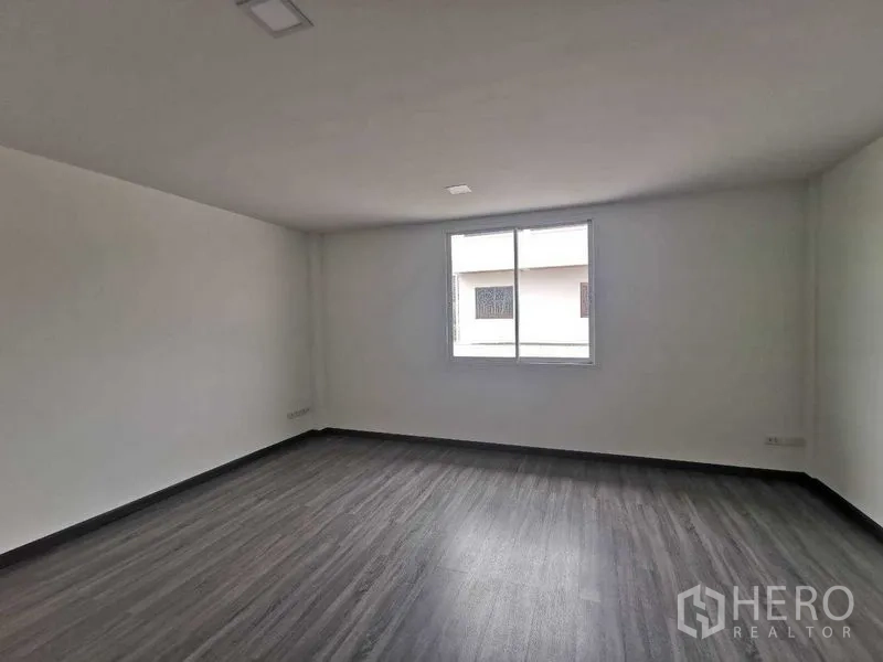 Home Office for rent or sale - Spacious empty bedroom with single window and wood-look flooring.