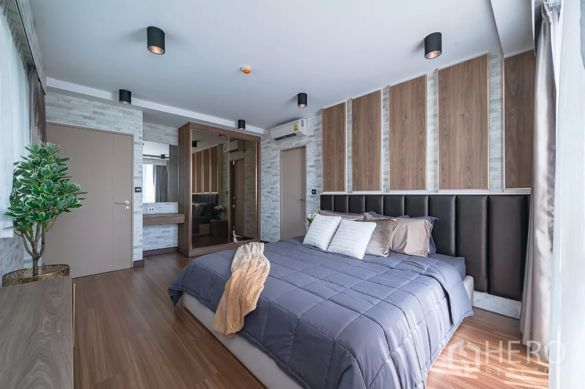 คอนโด ให้เช่าหรือขายในPhra Khanong, Bangkok - ห้องนอนหลักพร้อมตู้เสื้อผ้าบานกระจกเงาและโต๊ะเครื่องแป้งโทนอบอุ่น