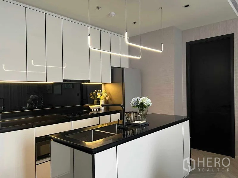 คอนโด ให้เช่าในKhlong San, Bangkok - ครัวโทนขาวดำพร้อมไอส์แลนด์ ซิงก์ เคาน์เตอร์เงางาม และไฟแขวนดีไซน์
