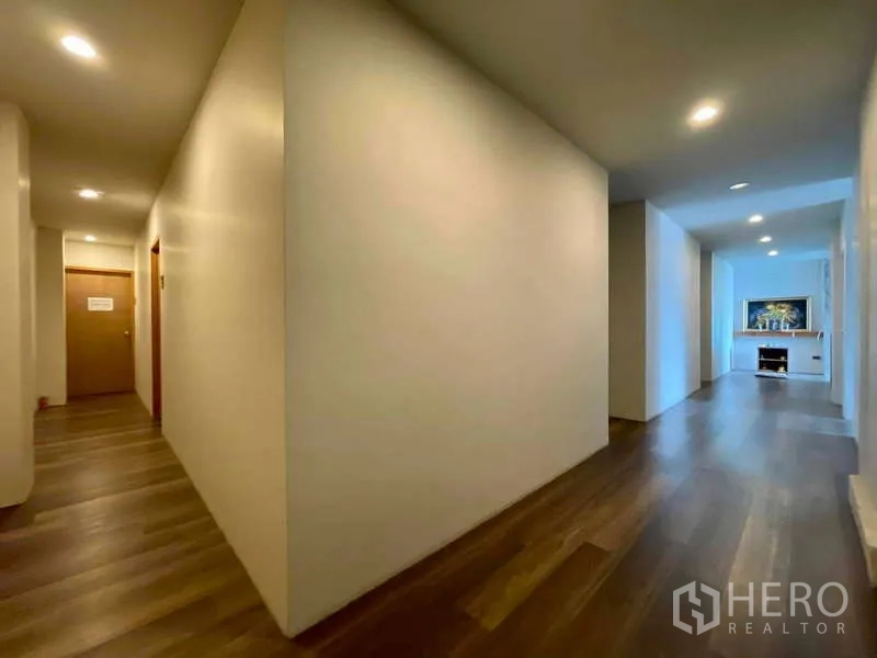 店屋 出租在Lat Phrao, Bangkok - 宽敞走廊，筒灯与木地板，通向起居区。