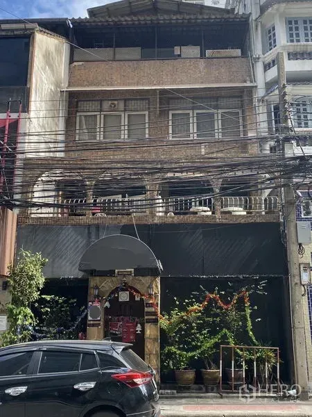 店屋 出售在Khlong Toei, Bangkok - 街景：多层砖砌店屋，拱形阳台、临街门面、盆栽与空中电线，位于曼谷空堤区。