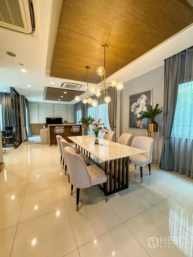 Detached House for rent or sale in Bueng Kum, Bangkok - Elegant dining area featuring a marble table, statement chandelier and sheer curtains.