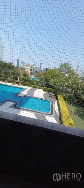 公寓 出租在Watthana, Bangkok - 窗外可见大型室外泳池与花园景观。