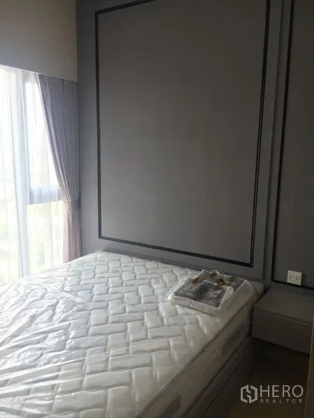 Condominium for sale - Cozy bedroom with a floor-to-ceiling window, curtains, paneled feature wall, and bed frame.