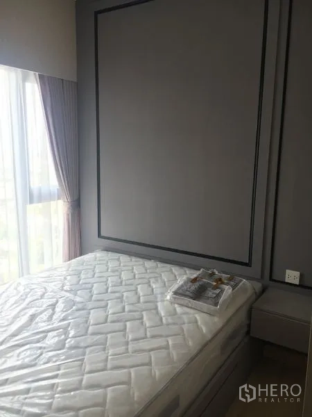 Condominium for sale - Cozy bedroom with a floor-to-ceiling window, curtains, paneled feature wall, and bed frame.