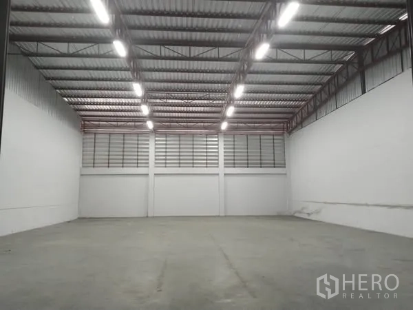 Warehouse for rent in Lat Krabang, Bangkok - Bright empty storage hall with LED lighting, ventilated panels, and smooth concrete floor