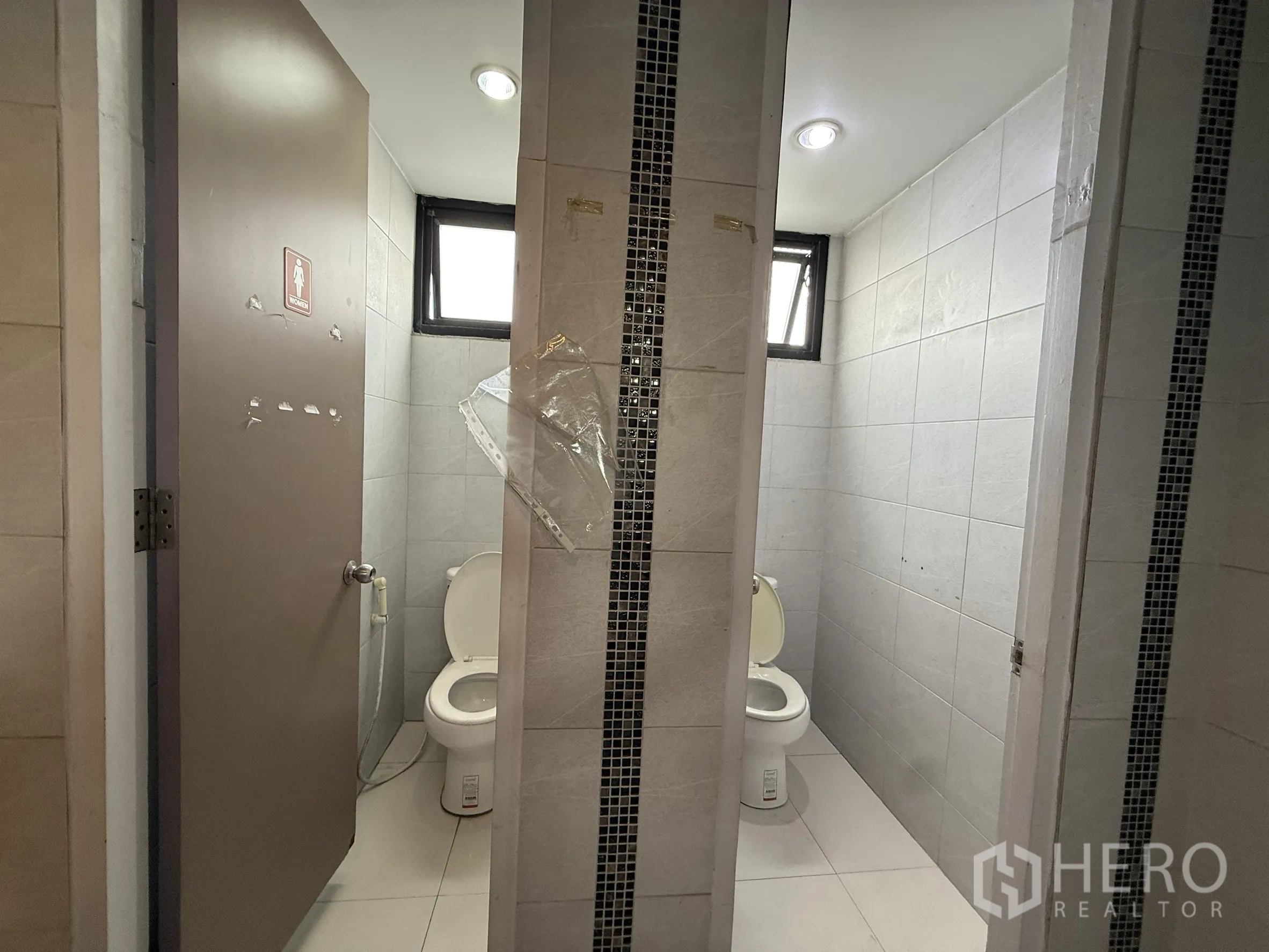 办公空间 出租在Din Daeng, Bangkok - 公共卫生间隔间，带小窗和瓷砖隔板。