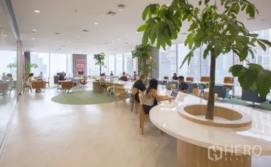 สำนักงาน ให้เช่าในKhlong Toei, Bangkok - เลานจ์โคเวิร์กกิ้งสว่าง โปร่ง โต๊ะยาว ต้นไม้ในอาคาร และกระจกบานใหญ่