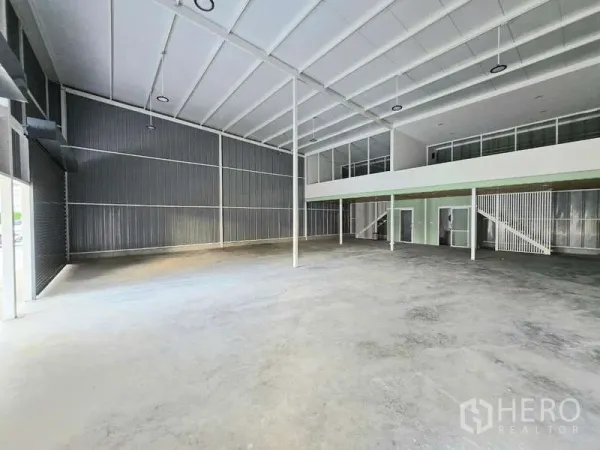Warehouse for rent in Wang Thonglang, Bangkok - Spacious high-clearance warehouse hall with steel roof trusses and mezzanine offices.