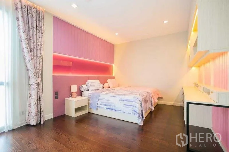 Detached House for rent in Bangkok - Pink-themed bedroom with built-in desk, LED-lit headboard and a large window.