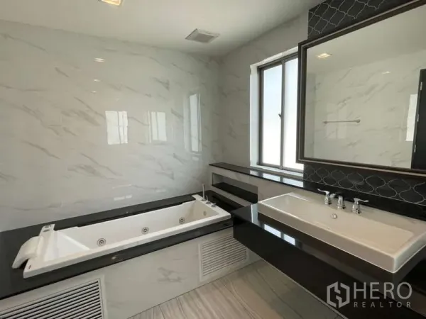 บ้าน ให้เช่าหรือขายในLat Krabang, Bangkok - ห้องน้ำโมเดิร์นพร้อมอ่างจากุซซี่ เคาน์เตอร์ยาว และกระเบื้องลายหินอ่อน