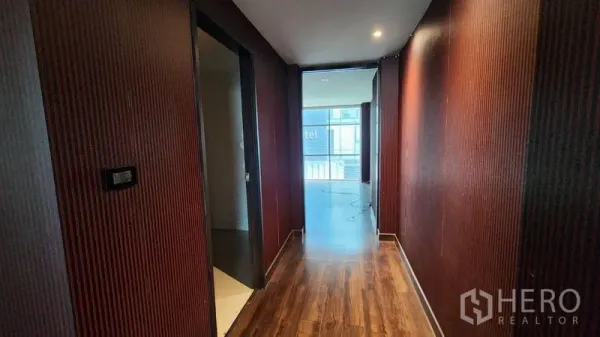 店屋 出租在Khlong Toei, Bangkok - 木地板走廊与纹理墙面，通往店面前侧窗景。