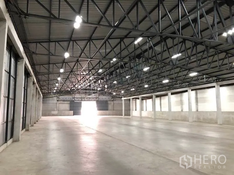 Warehouse for rent in Pak Kret, Nonthaburi - Spacious renovated warehouse interior with high steel truss roof, bright LED lighting and polished concrete floor in Pak Kret.