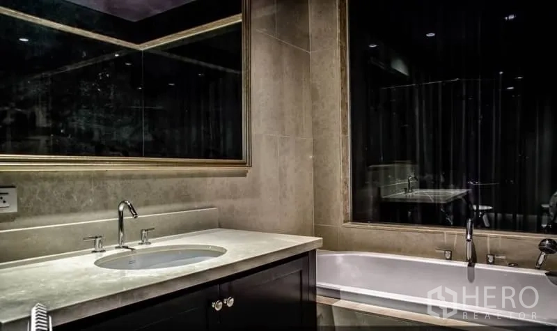 公寓 出租或出售在Khlong Toei, Bangkok - 酒店风浴室，长台盆、大镜子与浴缸。