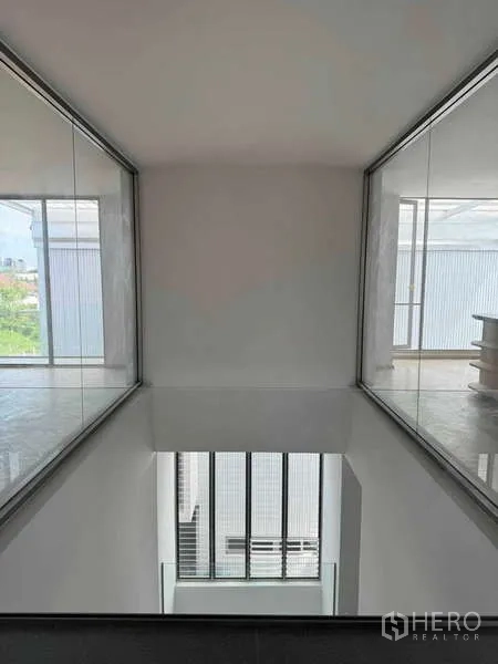 สำนักงานที่บ้าน ให้เช่าหรือขาย - สะพานทางเดินชั้นบนมองลงสู่โถงดับเบิลโวลุ่ม ผนังกระจกสองฝั่ง