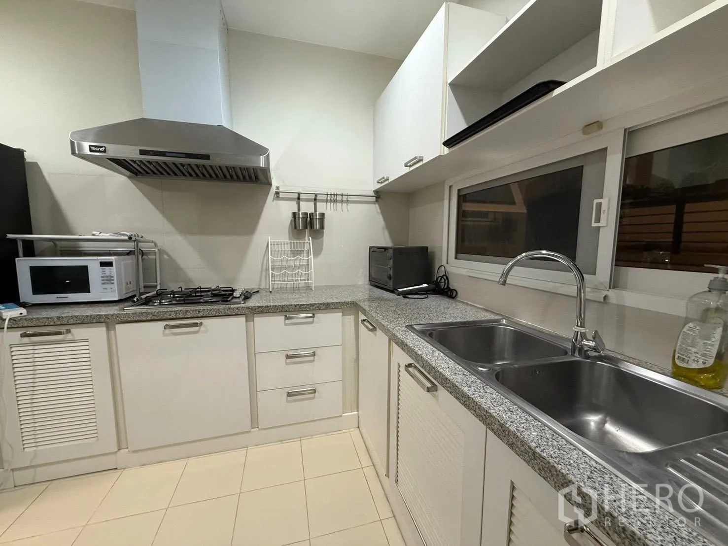 Detached House for rent in Bang Na, Bangkok - Thai kitchen countertop with double sink, gas hob and stainless hood.