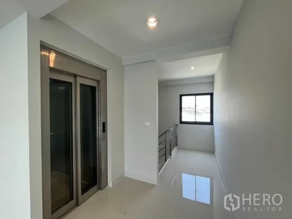 Home Office for rent - Corridor with stainless-steel private lift and a window bringing natural light onto the polished floor.