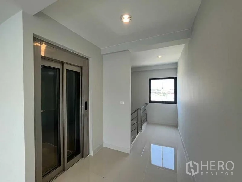 Home Office for rent - Corridor with stainless-steel private lift and a window bringing natural light onto the polished floor.