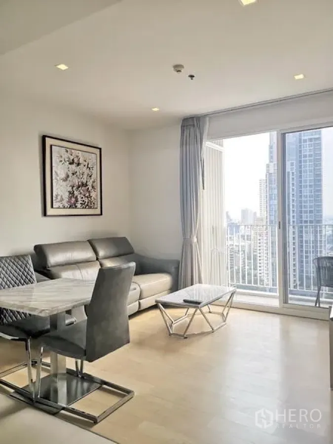 公寓 出租在Watthana, Bangkok - 采光充足的客厅，真皮沙发、石材茶几并连接可观赏天际线的阳台。