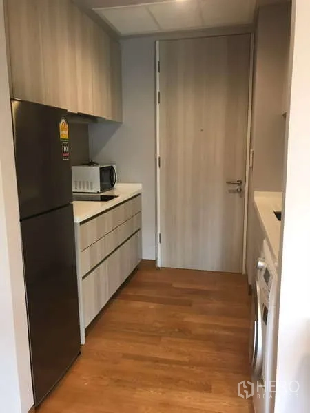 คอนโด ให้เช่าในKhlong Toei, Bangkok - โถงครัวทางเข้าพร้อมตู้เย็น ไมโครเวฟ และตู้ลายไม้ รวมทั้งเครื่องซักผ้า