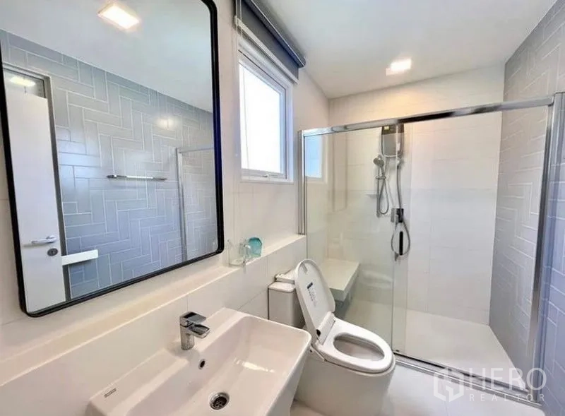 บ้าน ให้เช่า - ห้องน้ำสไตล์โมเดิร์น กระจกเงาบานใหญ่ ฉากกั้นอาบน้ำกระจก และสุขภัณฑ์สีขาว