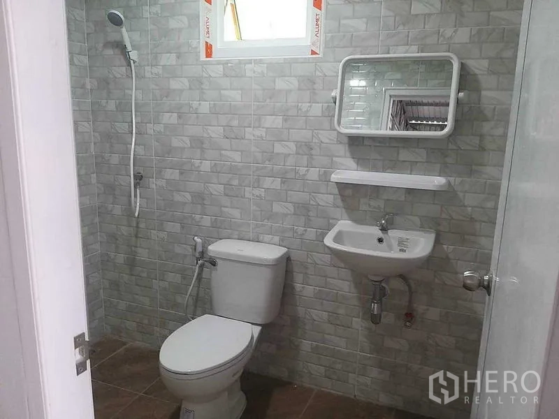 Warehouse for rent in Bang Khun Thian, Bangkok - Clean tiled restroom with toilet, sink, and shower inside the warehouse.