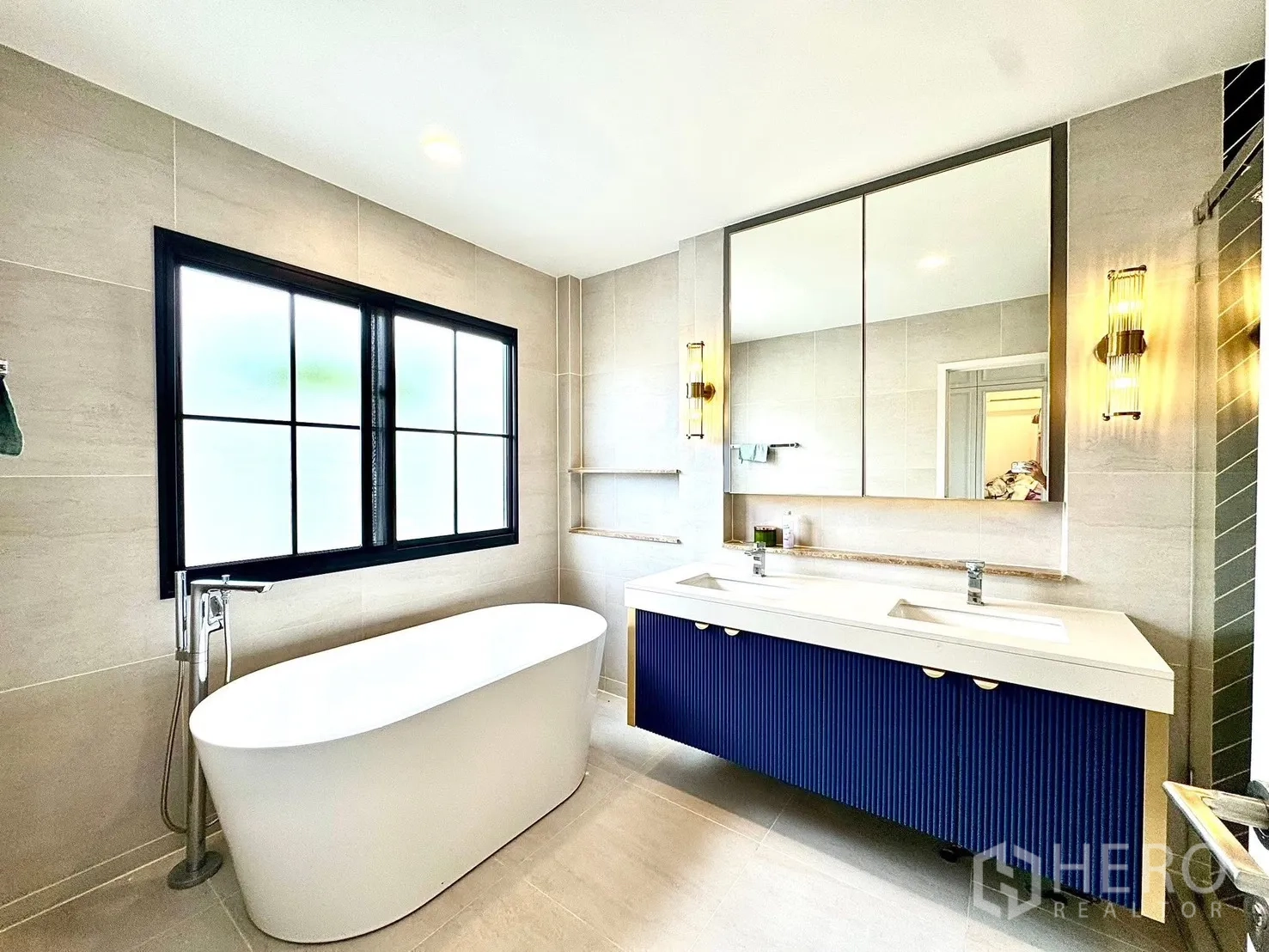 Detached House for rent in Bang Phli, Samut Prakan - Bathroom featuring a freestanding oval bathtub by a black-framed window and a double-sink vanity.