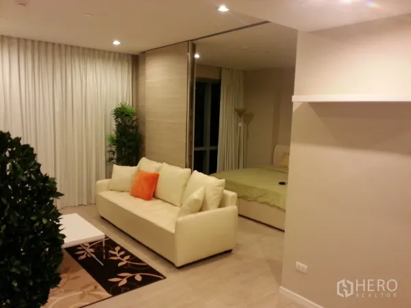 คอนโด ให้เช่าหรือขายในWatthana, Bangkok - พื้นที่นั่งเล่นแบบเปิดโล่ง โซฟาครีม โต๊ะกลาง และฉากกั้นเลื่อนสู่ห้องนอน