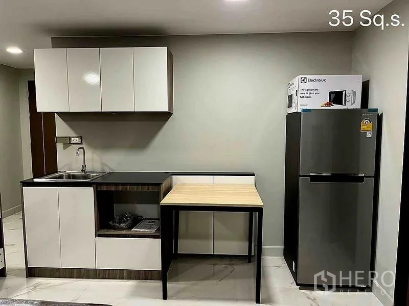 零售空间 出售在Khlong Toei, Bangkok - 厨房墙面区，水槽、橱柜、冰箱与微波炉盒。