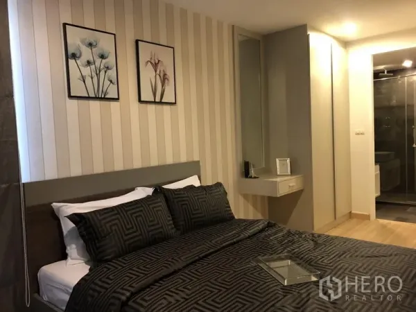 Condominium for rent in Watthana, Bangkok - Second bedroom with dark bedding, wall art, built-in wardrobe, vanity, and an en-suite shower.