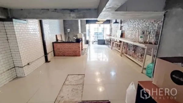 零售空间 出租在Watthana, Bangkok - 宽敞咖啡馆式布局，裸砖特色墙、长吧桌与亮面地砖。