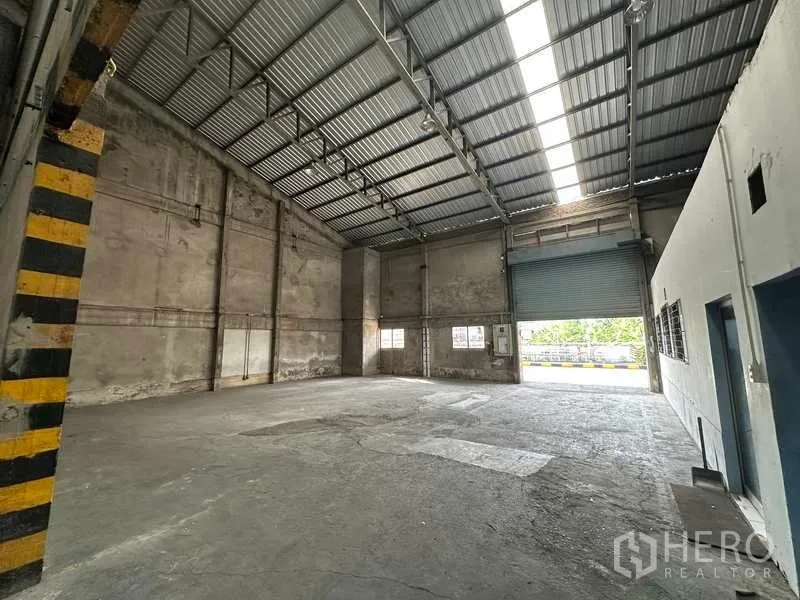 货栈 出租在Mueang Pathum Thani, Pathum Thani - 仓库货湾设宽幅卷闸门，采光板与通风良好。